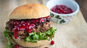 Moose burger with lingonberry jam on a wooden table