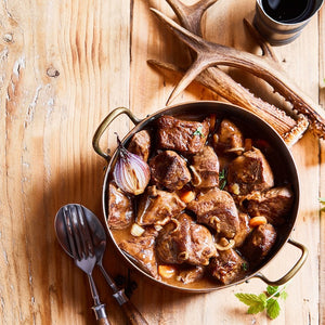 Wild game stew on wooden table with antlers from Swedish Wild